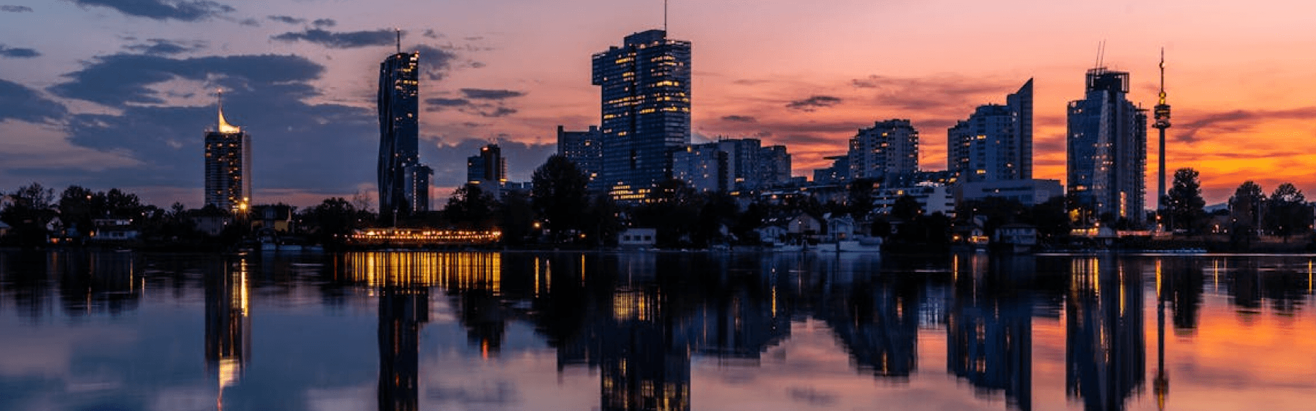Stadtsilhouette bei Sonnenuntergang, die sich im Wasser spiegelt